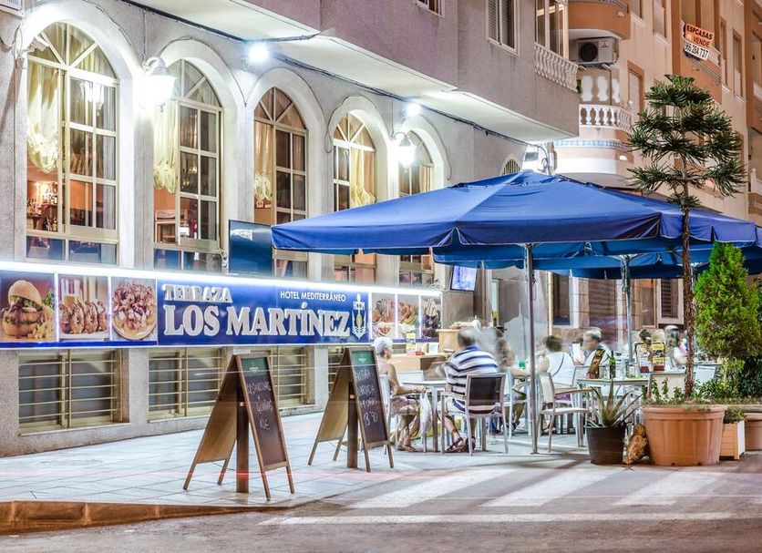 Hotel Mediterraneo in Guardamar del Segura with street-facing terrace dining and blue umbrellas