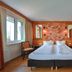 Rothenfels Panorama Hotel guest room with twin beds, wood accents, and mountain-view window in Immenstadt im Allgäu