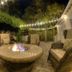 The Beaufort Inn in Beaufort: outdoor patio with fire pit, wicker chairs, and string lights at night