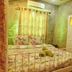 Khobjaina Homestay Soi 4 in Chiang Khan: floral bed, sheer curtains, and warm-lit cozy guest room