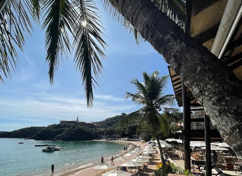 Hotel Ville La Plage & Beach Club in Búzios overlooking a tropical beach with palm trees and calm bay