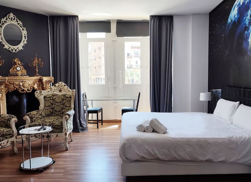 Flats Friends Plaza de la Reina Valencia guest room with bed, ornate seating, and city-view window