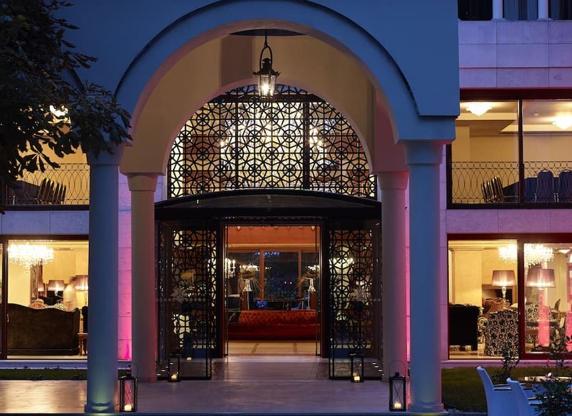 Grand Serai Congress & Spa in Ioánnina entrance with arched portico and lit lobby at dusk