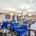 La Quinta Inn & Suites by Wyndham Karnes City - Kenedy lobby with blue chairs, tables and breakfast seating