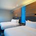 Aloft Waco Downtown guest room with two beds, blue accent wall and modern workspace in Waco