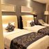 Century Palace Hotel Huiyang in Huizhou guest room with two twin beds, desk, chair, and curtained window