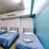 Global Backpackers Cairns Central dorm room with three single beds and teal accent wall in Cairns
