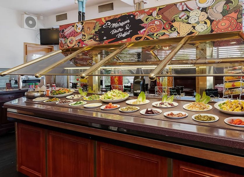 Marquis Hotel Motel Hobart buffet counter with assorted salads and dishes beneath colorful mural