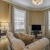 Hotel Bothwell Sedalia Central District, an Ascend Collection Hotel guest room with tufted sofas and windows