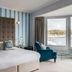 Greenbank Hotel Falmouth room with bay window, upholstered chair, and harbor view