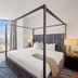 Placemakr Premier Sobro Nashville bedroom with canopy bed and city view through tall window