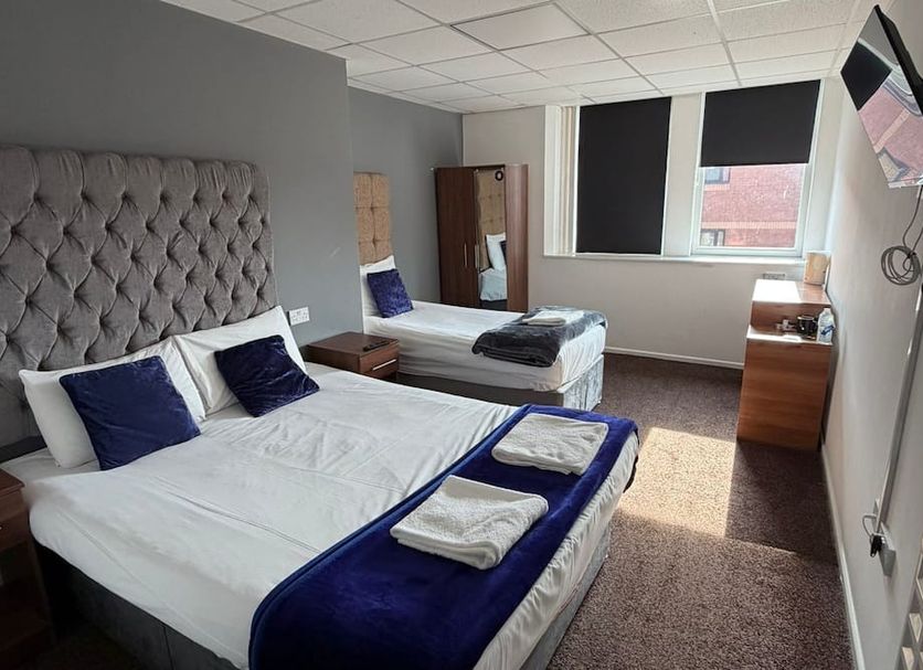 Parkview Residence Manchester guest room with two beds, windows, and wall-mounted TV