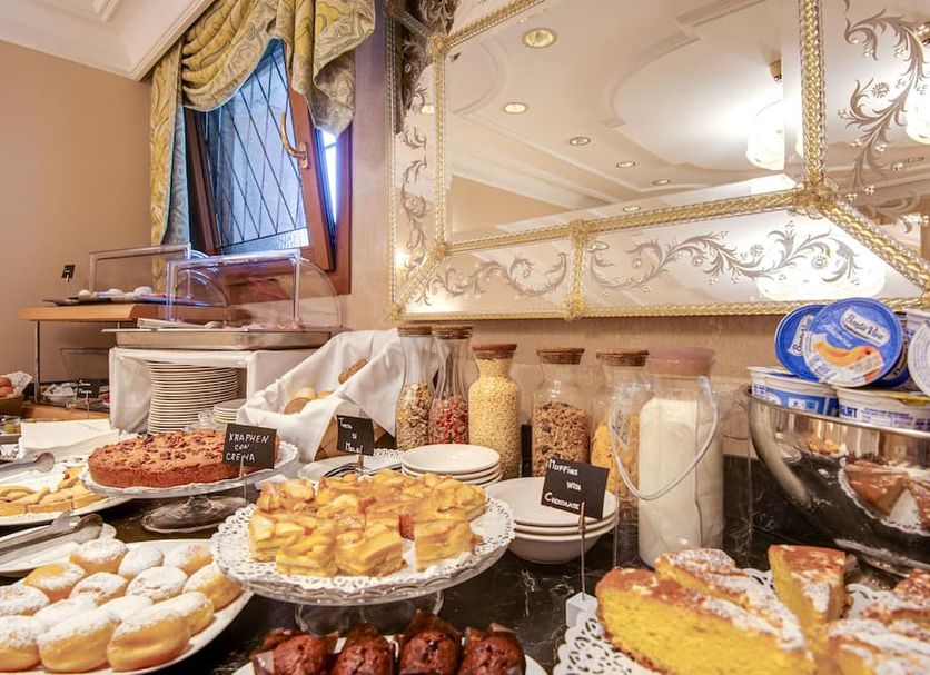 Hotel Antiche Figure in Venice breakfast buffet with pastries, cereal jars, and coffee cups
