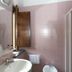 Hotel Ristorante Molino D'era bathroom in Volterra with pink tile walls, sink, mirror, and wall-mounted hair dryer
