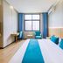Zhoushan Dinghai New Donggang Hotel room with king bed, blue accents, desk, and city view