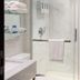 Hotel Mirage Brooklyn bathroom with marble-look tile, glass shower, towel bar and vanity in Brooklyn