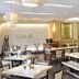 Royal Garden Hotel Ozamiz dining area with tables, benches, pendant lights and wall art