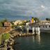 Hotel Restaurant Du Port in Yvoire with a docked white boat on the waterfront under stormy skies