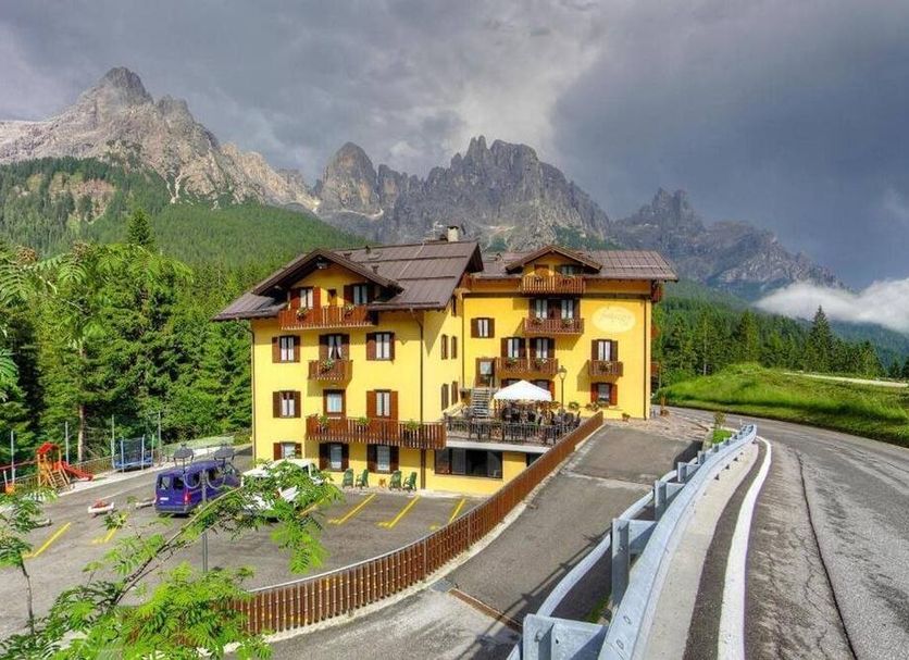 GH Hotel Fratazza in San Martino di Castrozza, alpine hotel with mountain backdrop and roadside parking