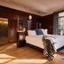 QT Sydney hotel room with king bed, wood-paneled walls, and large window seating area
