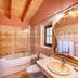Agroturismo Es Quatre Cantons bathroom in Binissalem with bathtub, glass shower, sink and ornate mirror