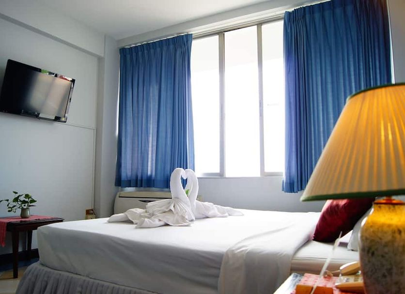 Ymca International Hotel Chiang Mai guest room with twin beds, blue curtains and wall-mounted TV