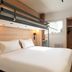Kyriad Eco Lille Sud - Noyelles Godault room with double bed, loft bunk bed, and compact kitchenette