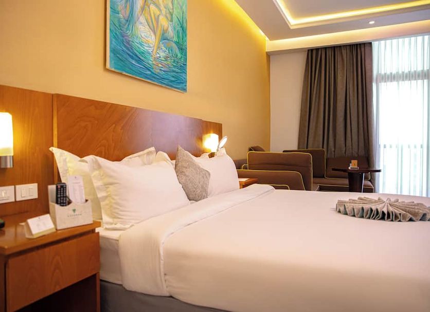 Azzeman Hotel Addis Ababa guest room with king bed, bedside lamps and city-view window