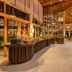 Kagi Maldives Resort & Spa buffet dining hall with curved counters and high wooden ceiling