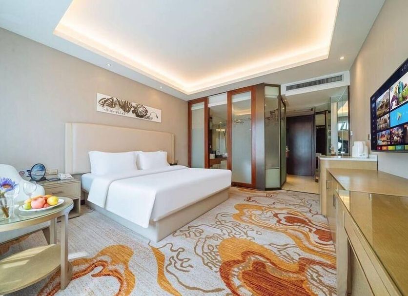 Hangzhou Zijingang International Hotel room with king bed, sitting area, and floral carpet in Hangzhou