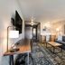 Four Points by Sheraton Elkhart guest room with sofa, desk, TV, and patterned rug