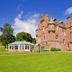 Cringletie House Hotel in Peebles, red-brick castle-style hotel beside a glass pavilion on a green lawn