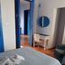 The Dreamers&Co in Córdoba guest room with twin bed, desk, mirror, and blue-trimmed doorway