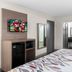 Red Roof Inn Richmond - Airport Sandston guest room with TV, mini-fridge, desk, and bathroom vanity