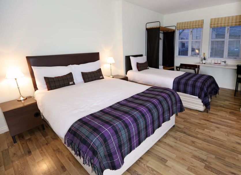 Hillhead Farm Lets in Stirling: bright twin bedroom with plaid throws, wood floors, and desk