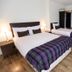 Hillhead Farm Lets in Stirling: bright twin bedroom with plaid throws, wood floors, and desk