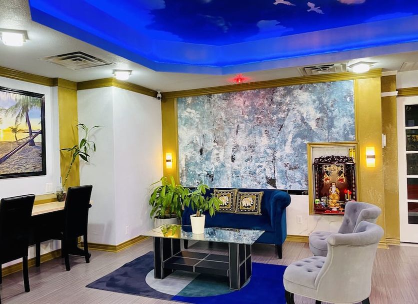 R Nite Star Inn and Suites lobby in Arlington with seating area, blue-lit ceiling, and wall art