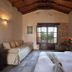 Castello Antico Hotel in Gytheio room with stone walls, wooden ceiling, bed, sofa and balcony view