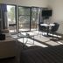 Metung Waters Motel and Apartments living room with sofa, table, TV, and sliding glass doors to patio
