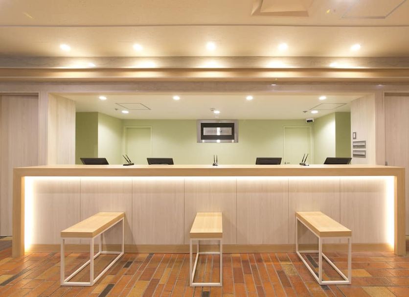 Hotel S-plus Hiroshima Peace Park lobby front desk with benches and warm lighting in Hiroshima