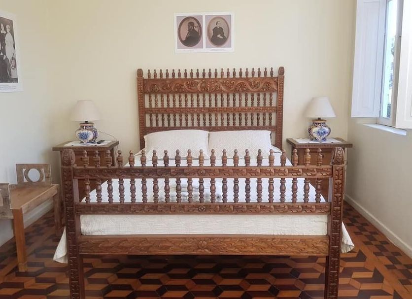 Pousada 14 Bis in Petrópolis: rustic wooden bed with carved headboard and matching bedside tables