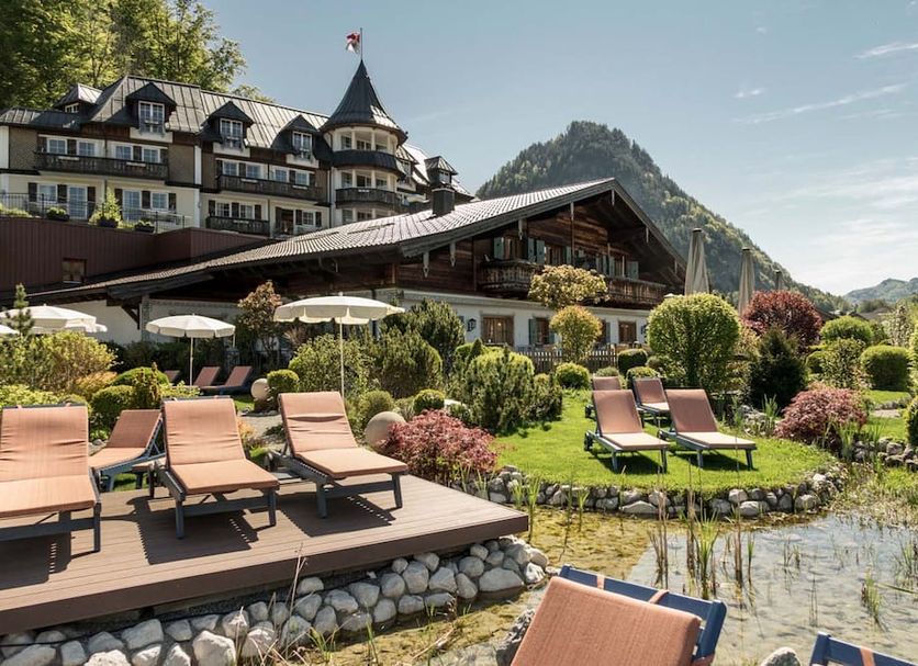Waldhof Fuschlsee Resort in Fuschl am See with sun loungers by a pond and mountain views