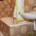 Apartments Alissa in Hvar bathroom with tiled tub, toilet, sink, and shower curtain