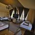 Vila Vidalis in Cluj Napoca guest room with three beds, chandelier, TV, and sloped ceiling