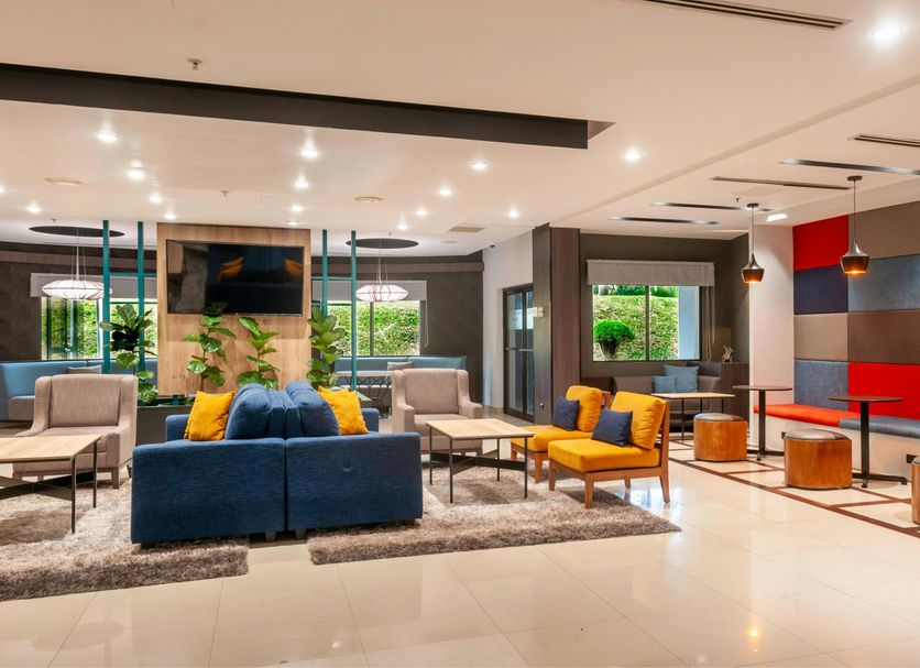 Courtyard by Marriott San Salvador lobby with blue sofa, lounge chairs, large windows and colorful wall panels