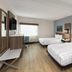 La Quinta Inn & Suites by Wyndham Atlanta Roswell guest room with two beds and a window desk