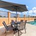 Days Inn by Wyndham Rockdale Texas pool patio with table, chairs, umbrella, and open sky