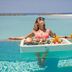 Kagi Maldives Resort & Spa in Kagi: woman enjoying a floating breakfast in an infinity pool overlooking the beach