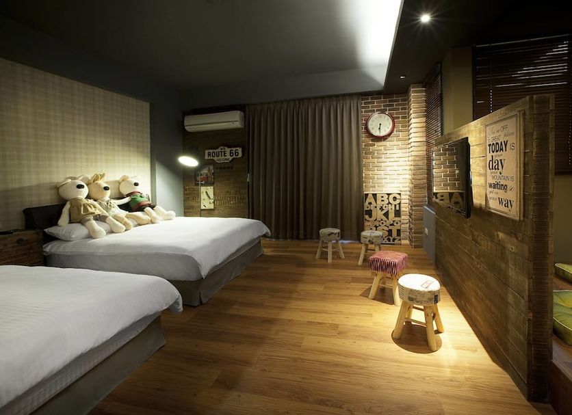 Spring Tree, Dongshan Township: cozy guest room with two beds, wood floors, brick wall and seating area