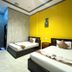 Golden Bakong Boutique Siem Reap room with two beds and bright yellow accent wall